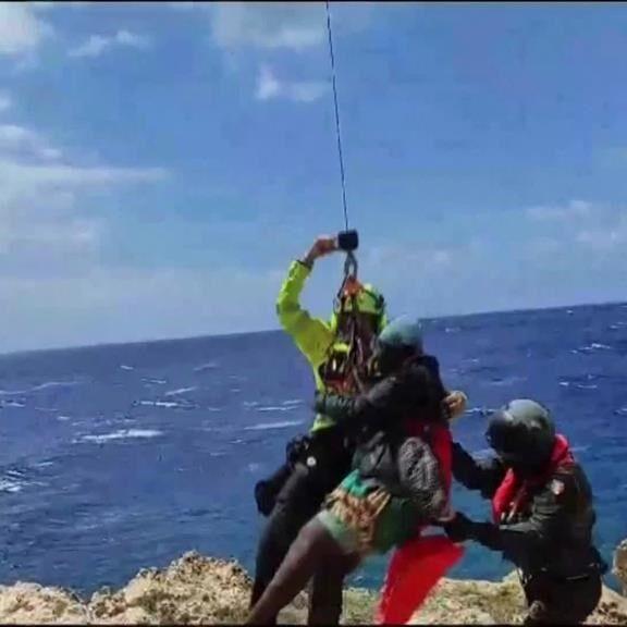 Dozens saved by Italy from migrant shipwrecks; some, clinging to rocks, plucked to safety by copters